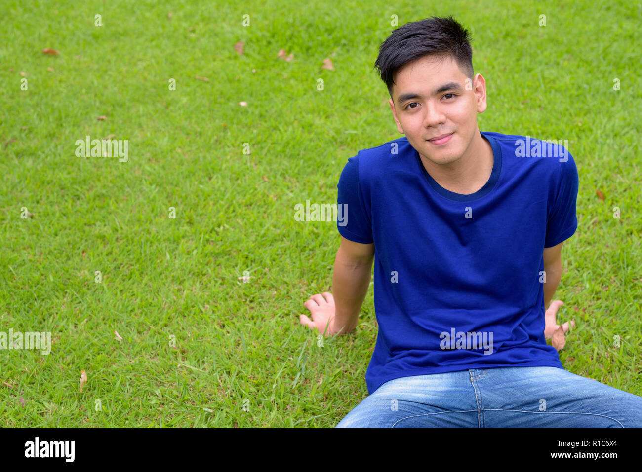 Die Jungen gut aussehenden asiatischer Mann Entspannung im Park Stockfoto
