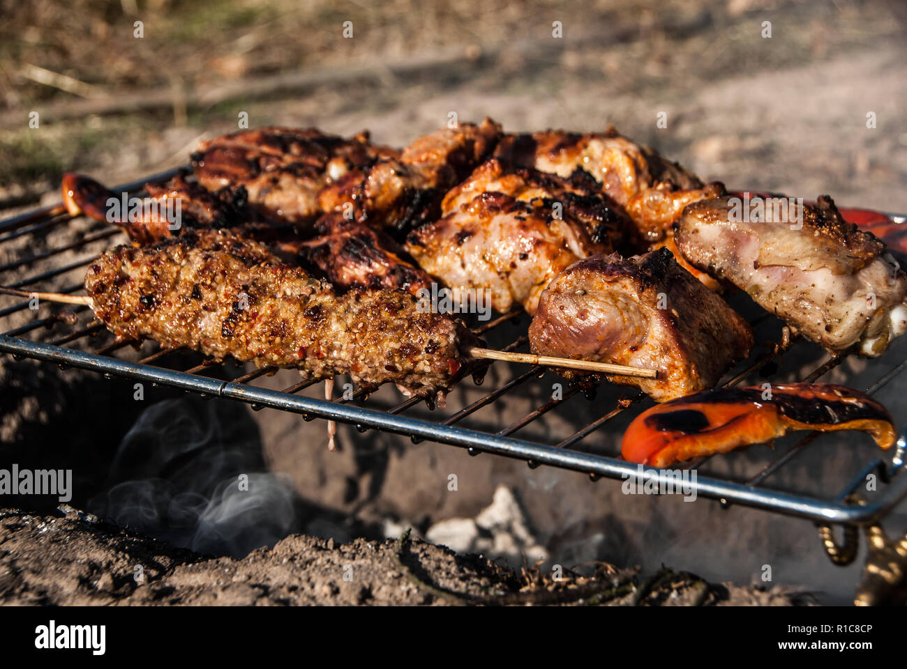 Fleisch und süßen roten Pfeffer shish Fleischspieße Grillen auf der Raster, in Rauch. Barbecue in touristische Forest Camp. Konzept - gesunde ernährung. Stockfoto