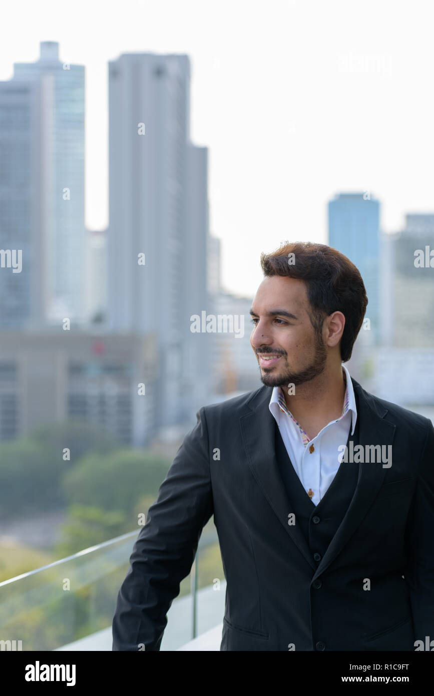 Nachdenklich glücklich indischer Geschäftsmann Lächeln beim Genießen der v Stockfoto