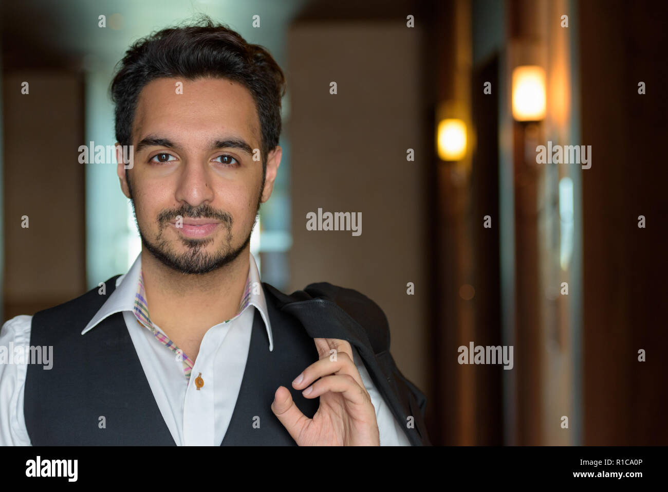 Junge schöne Indische Mann mit Jacke in den Korridoren der Hot Stockfoto