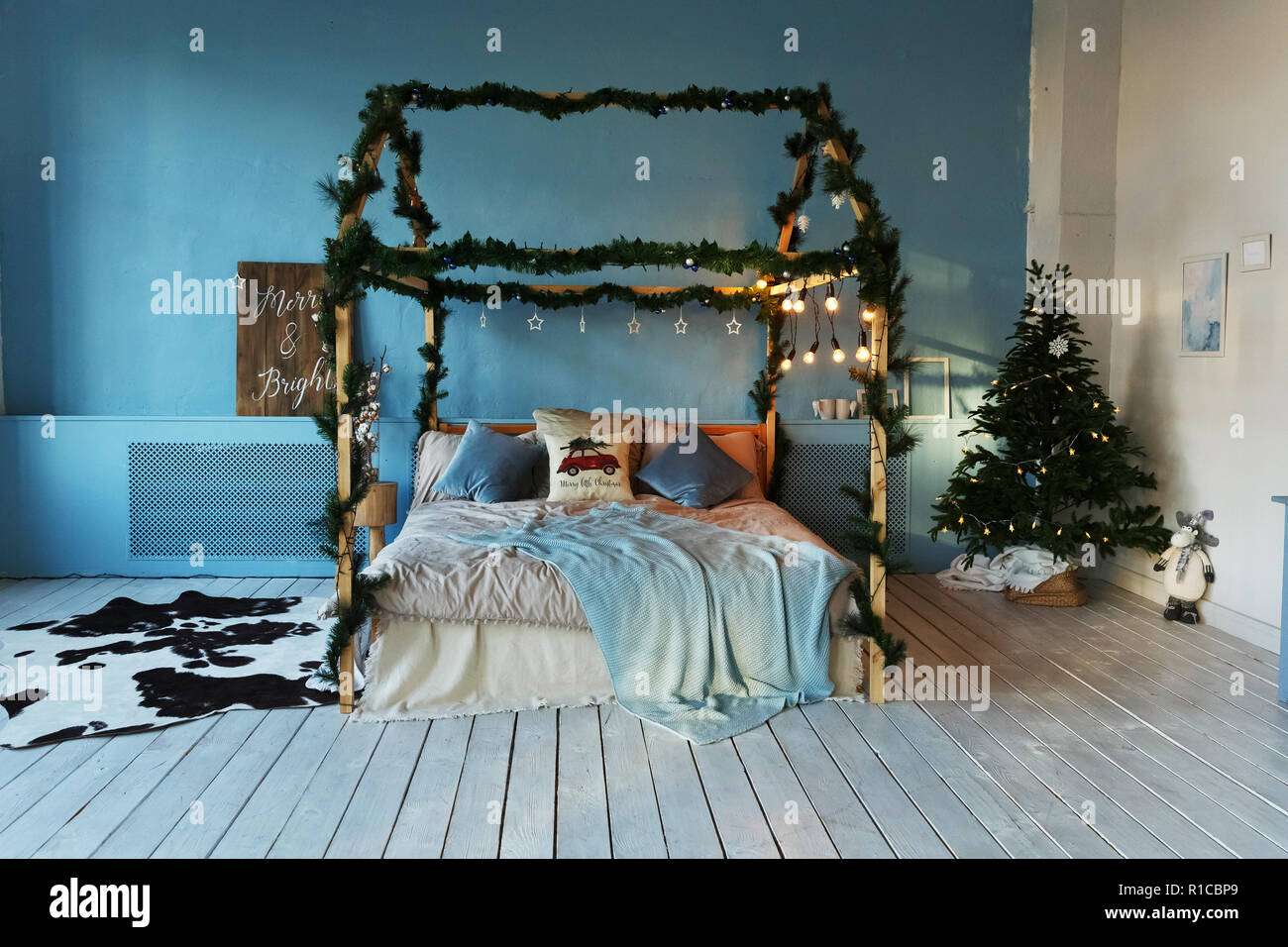 Blaue Zimmer mit Bett für Weihnachten mit Baum und Lichtern geschmückt  Stockfotografie - Alamy