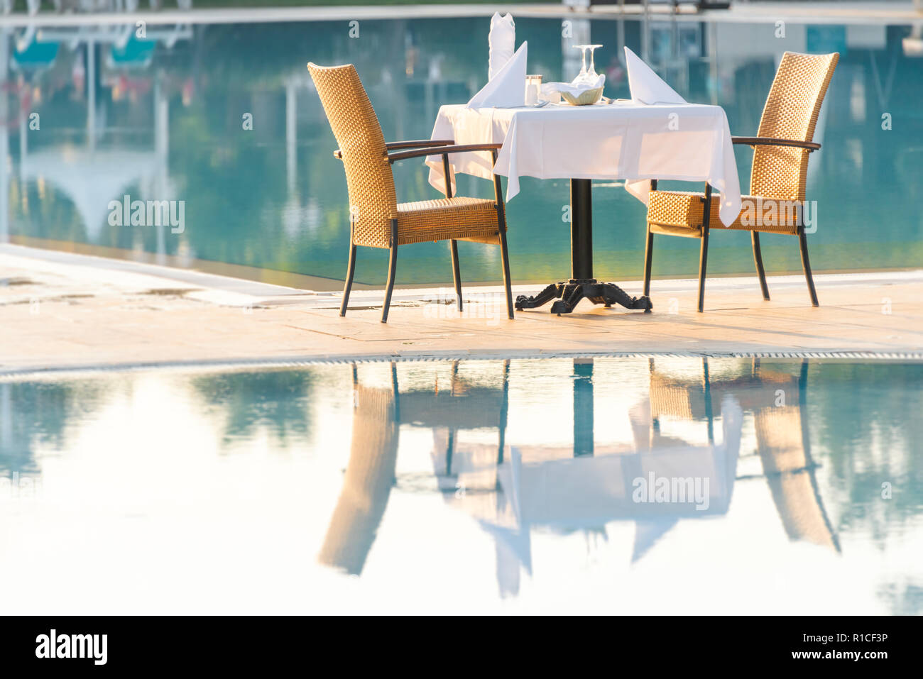 Stühle und Tisch in der Nähe der Pool im Hotel Restaurant. Besteck und napkings auf Tabellen. Resort leben auf Urlaub. Stockfoto