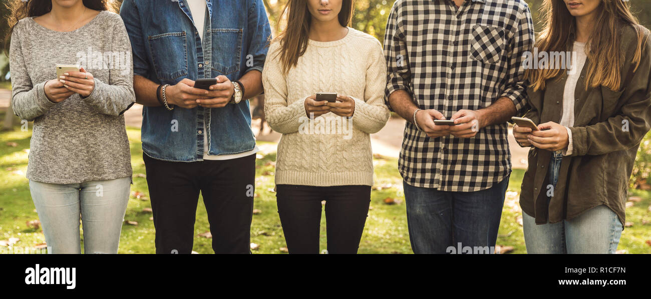 Eine Gruppe von Freunden mit sozialen Netzwerken auf ihren Handys abgelenkt Stockfoto