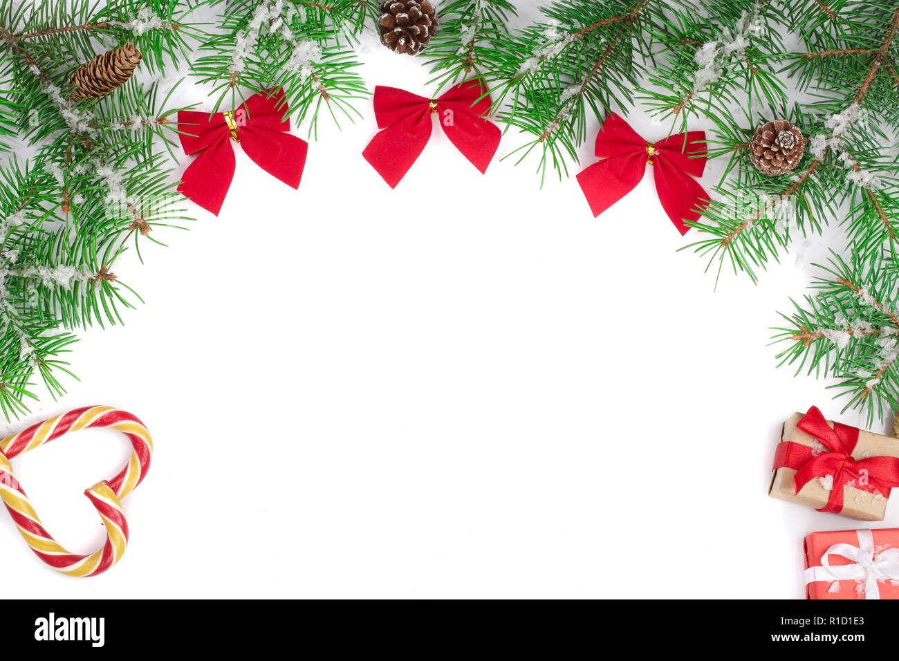Weihnachten Rahmen der Fir Tree Branch mit Zuckerstangen und Bögen auf weißem Hintergrund mit Kopie Platz für Ihren Text isoliert Stockfoto