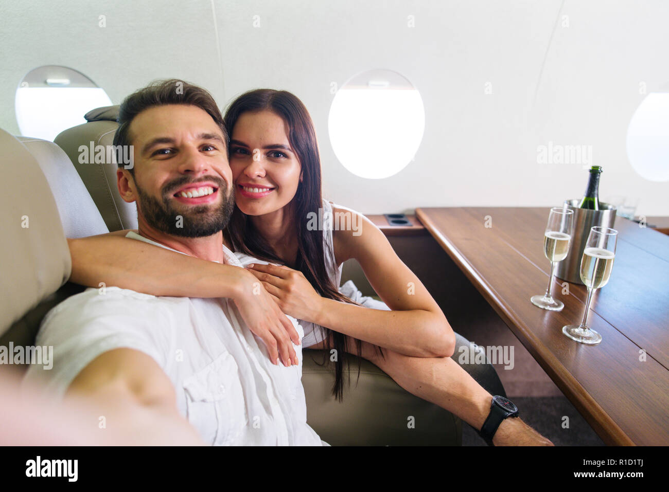 Glückliches Paar Reisen auf einem luxuriösen Privatjet - Junge Erwachsene Reisen auf einem First Class Flug, Konzepte über die Reise und Lifestyle Stockfoto