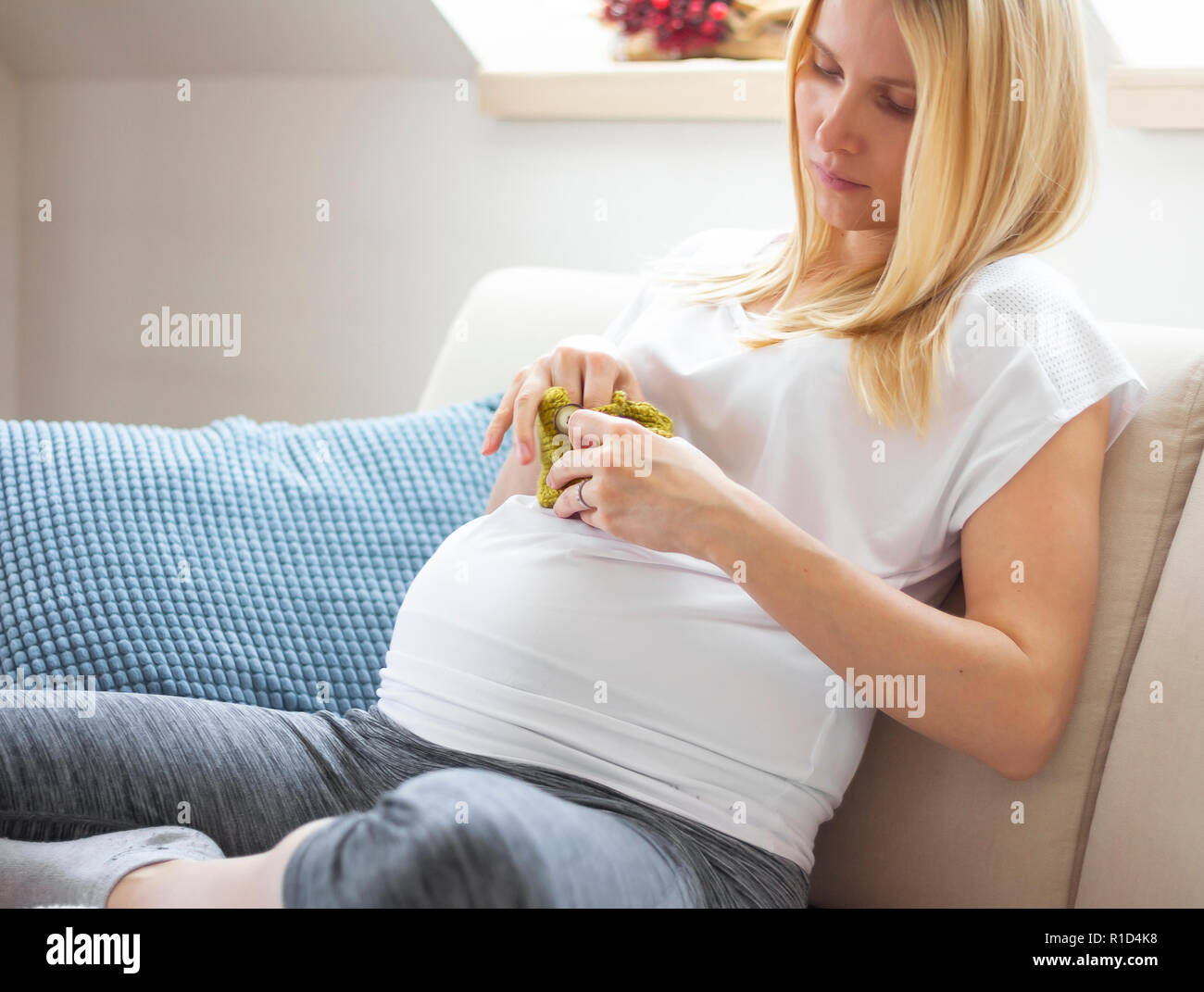 Schwangere Frau auf dem Sofa zu Hause sitzen Stockfoto