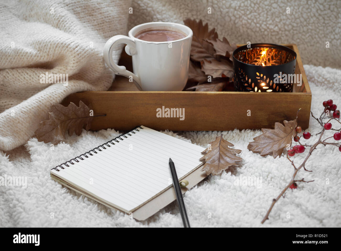 Leer Notebook mit Becher Kaffee auf warmen Baumwollgewebe Stockfoto