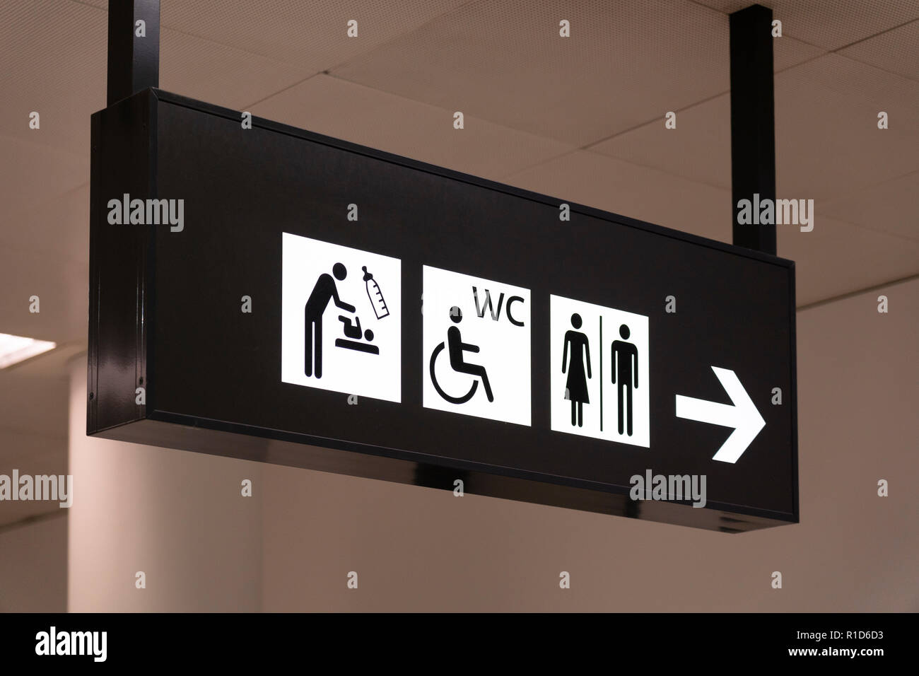 Ein schwarz-weißes Schild mit Wegbeschreibungen für die Toiletten im Terminal 3 am Flughafen Wien Stockfoto