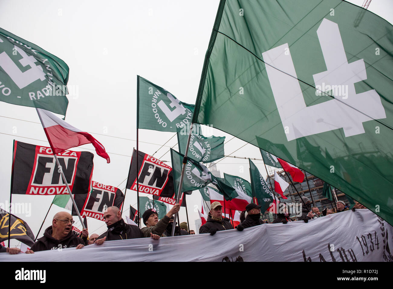 Menschen schwenkten die falanga Flagge von Onr und der italienischen faschistischen Forza Nuova Symbol. Polen feiert das 100-jährige Jubiläum seiner Wiedergeburt als ein unabhängiger Staat. Rund 200.000 Menschen nahmen an einem Tag der Unabhängigkeit März in Warschau. Der März war von zwei Versammlungen, mit einer offiziellen Feier, die von der Regierung organisiert von einem anderen durch die Unabhängigkeit März Verein organisiert. Stockfoto