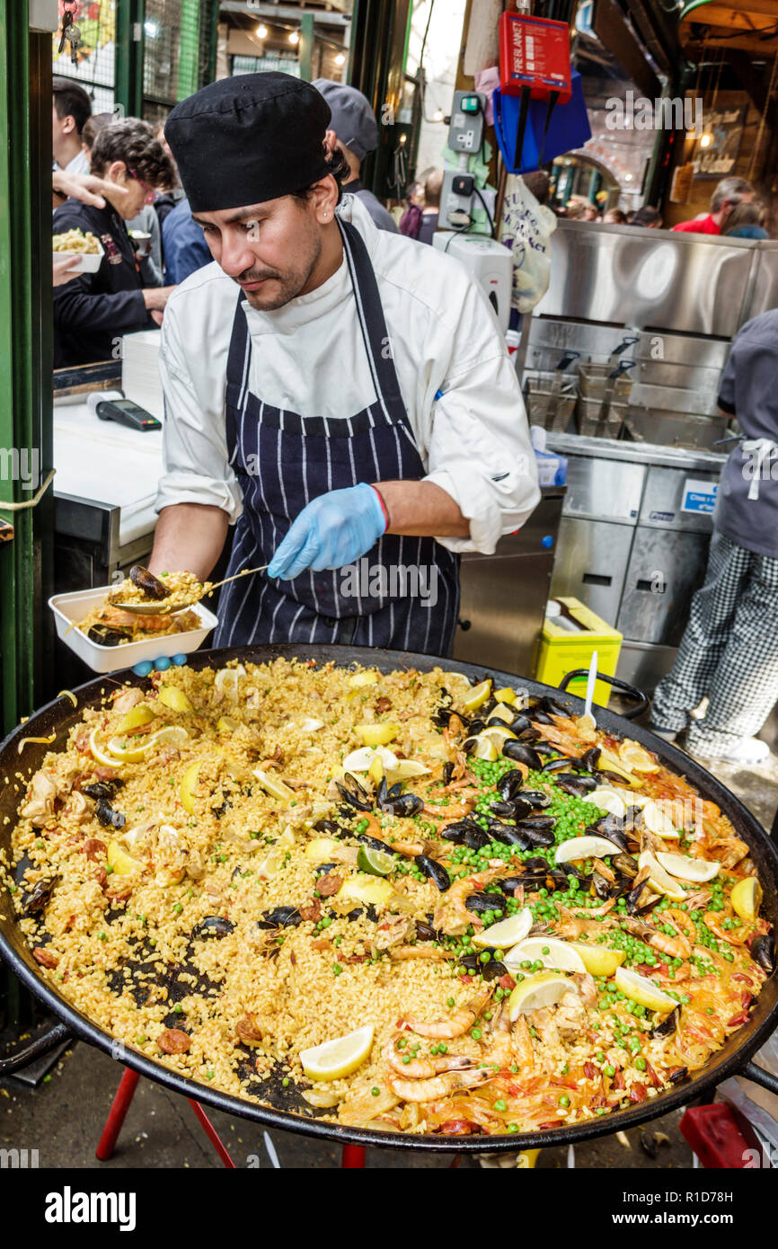 London England, Großbritannien, South Bank Southwark, Borough Market, Verkaufsstände, Lebensmittelzubereitung, Paella mit Meeresfrüchten, hispanischer Mann, Männer, Koch, Scheckservieren, Handschuhe, f Stockfoto