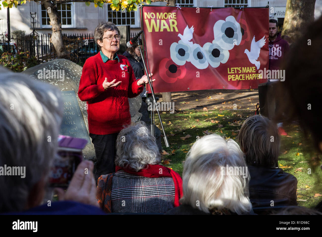 London, Großbritannien. 11. November 2018. Sue Gilmurray der Anglikanischen pazifistischen Fellowship liest ein Gedicht mit anderen Friedensaktivisten und Unterstützer die Teilnahme an einer Zeremonie des Gedenkens und des Friedens in Tavistock Square auf der 100. Jahrestag der Unterzeichnung der Waffenstillstand, dem Ende des ersten Weltkriegs markiert. Credit: Mark Kerrison/Alamy leben Nachrichten Stockfoto