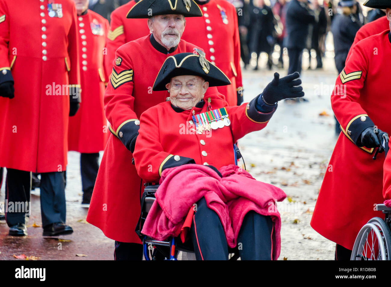 London, Großbritannien. November 2018. Ein Rentner aus Chelsea, der die berühmte scharlachrote Uniform trägt, winkt der Menge zu, während er an der Parade zum Gedenken an den 100. Jahrestag des Endes des Ersten Weltkriegs teilnimmt. Stockfoto