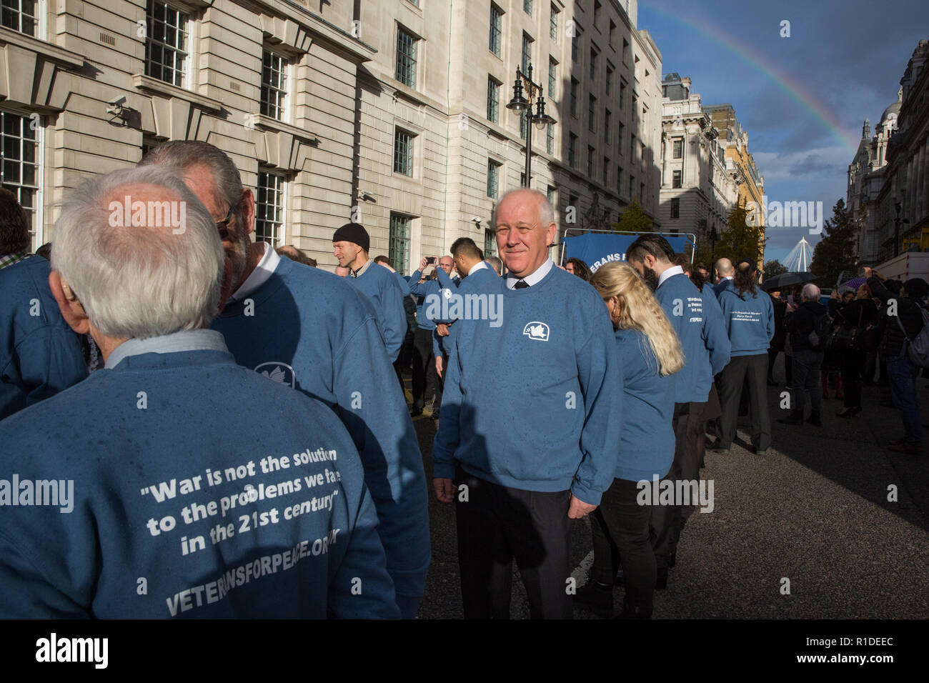 London, Großbritannien. 11. November 2018. Ein Regenbogen erscheint über Ex-Mitarbeitern von den Veteranen für den Frieden UK (VFP-UK) Vorbereiten der Erinnerung Sonntag Zeremonie am Ehrenmal in London auf den 100. Jahrestag der Unterzeichnung der Waffenstillstand, dem Ende des Ersten Weltkriegs markiert zu besuchen. VFP UK wurde 2011 gegründet und arbeitet die Außen- und Verteidigungspolitik der UK für das größere Ziel der Frieden in der Welt zu beeinflussen. Stockfoto