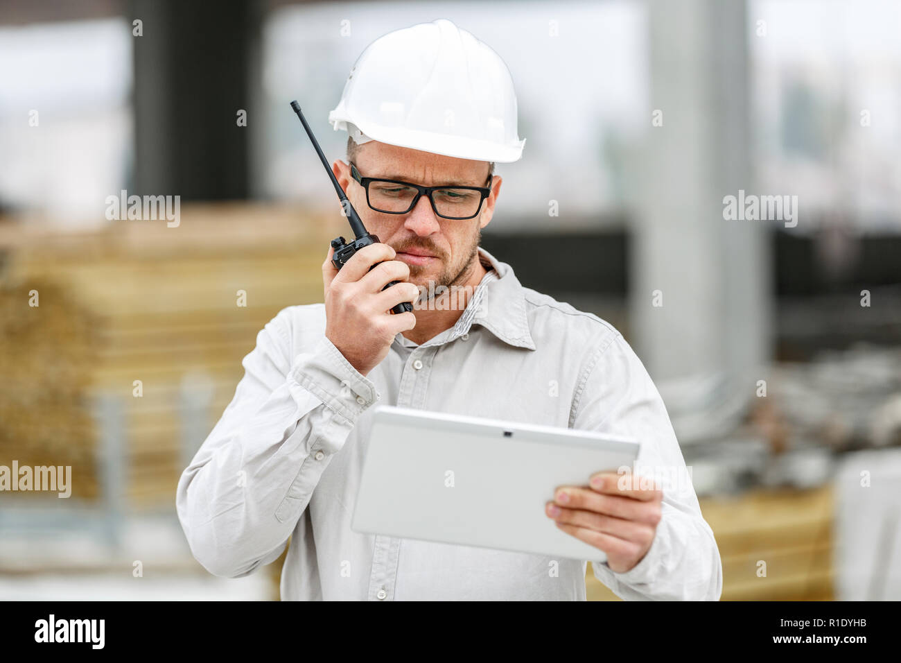 Männliche Leiter Ingenieur tragen weiße Sicherheit hardhat mit Walkie talkie und Tablet Inspektion Baustelle. Technologie, Entwicklung und Bau ich Stockfoto
