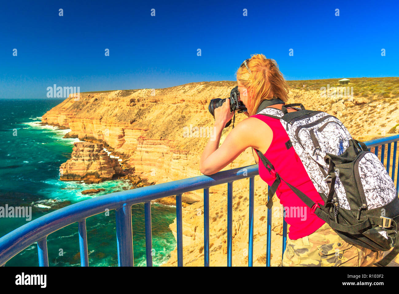 Reisen Fotograf nimmt der natürliche Brücke Aussichtspunkt in Kalbarri Nationalpark, Western Australia, Australien Outback. Weibliche Touristen nimmt Bilder mit einer professionellen Kamera auf den Indischen Ozean Klippen Stockfoto