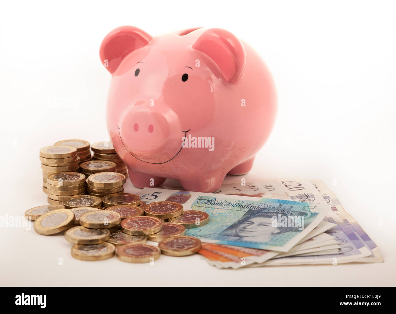 Rosa Sparschwein auf viele Pfund Noten und Pound Münzen Stockfoto