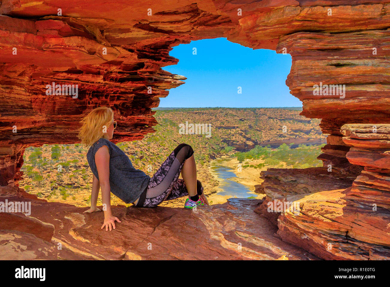 Kaukasische Frau im Rock arch im roten Sandstein von der Natur für Fenster, Blick auf den Murchison River im Kalbarri Nationalpark, Western Australia. Australien reisen Outback. Stockfoto