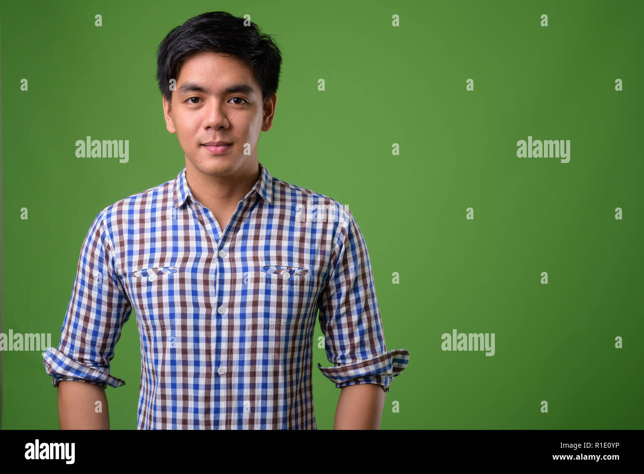 Junge schöne Filipino Mann gegen grüner Hintergrund Stockfoto