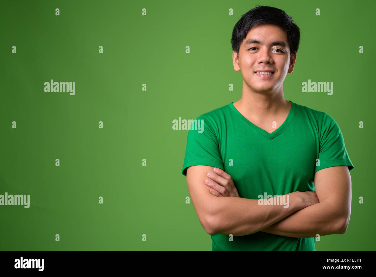 Junge schöne Filipino Mann gegen grüner Hintergrund Stockfoto