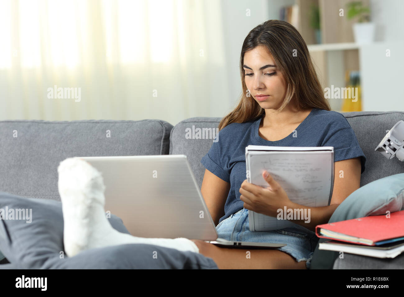 Behinderte Schüler-e-learning mit einem Laptop auf der Couch im Wohnzimmer zu Hause sitzen Stockfoto