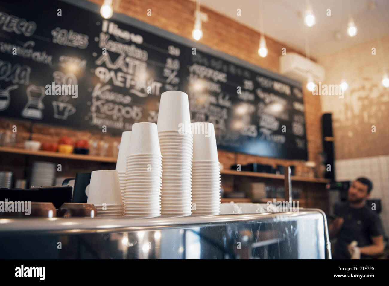 Hipster suchen Coffee Shop bereit für den Tag mit einem Sauber und ordentlich Zähler zu öffnen und gut gepflegte glänzende Kaffeemaschine auf der Holzoberfläche Stockfoto