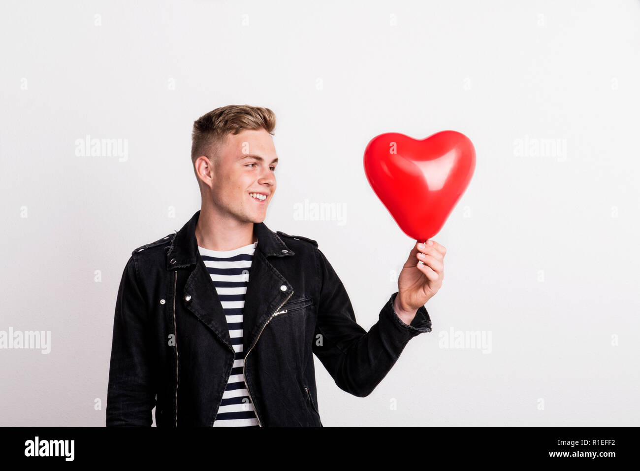 Ein Junger Mann Verliebt Sich In Ein Studio Halt Ein Rotes Herz Ballon Stockfotografie Alamy