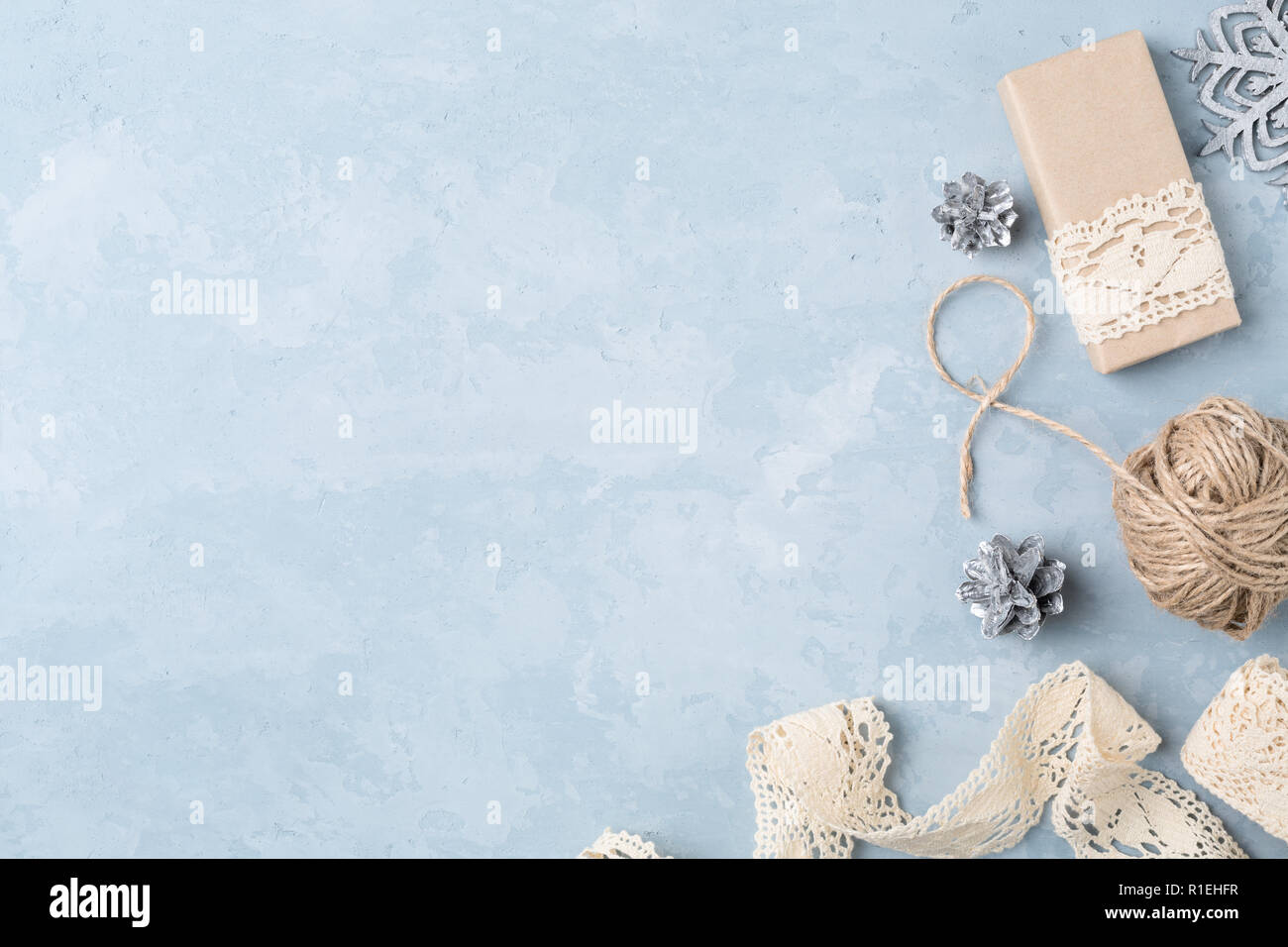 Geschenkverpackung Dinge auf blauem Hintergrund. Spitze, braunes Papier, Hanf, Weihnachtsschmuck mit kopieren. Blick von oben. Stockfoto