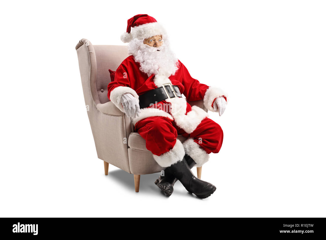 Überrascht Weihnachtsmann im Sessel auf weißem Hintergrund sitzen Stockfoto