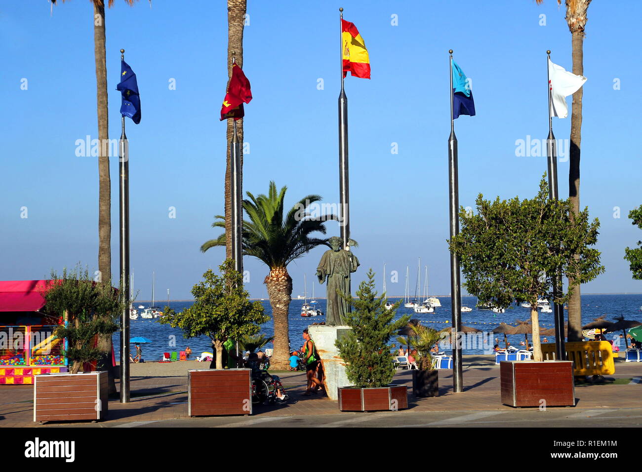 Santiago de la Ribera, Murcia, Spanien - 31. Juli 2018: Die Statue "Hommage an die Pilger, die von Juan Jose Quiros, Auf der Explanada Barnuevo, mit Fahnen in Stockfoto