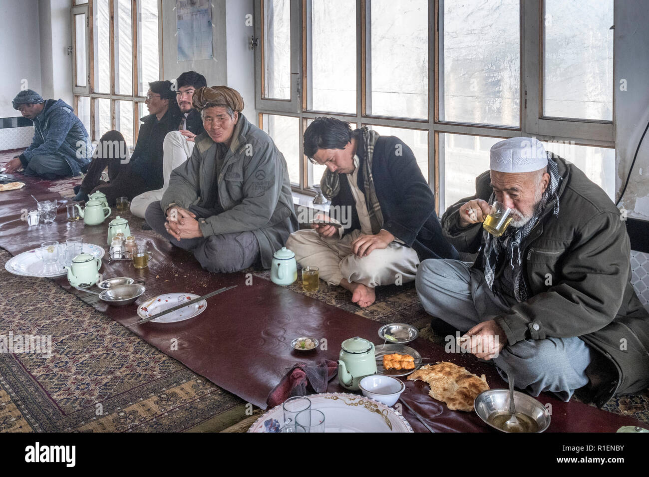 Männer sitzen auf dem Boden ein Mittagessen in einem traditionellen Restaurant, Bamian, Provinz Bamyan, Afghanistan in Stockfoto