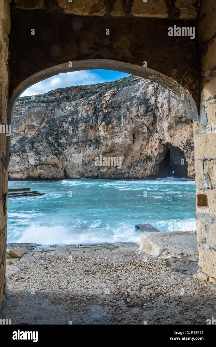 An einem hellen, sonnigen Wintertag mit rauer See in Dwejra Binnenmeer. Höhle, diese kleine Bucht mit dem externen Mediterrane sauberes Wasser verbindet. Kopieren Stockfoto