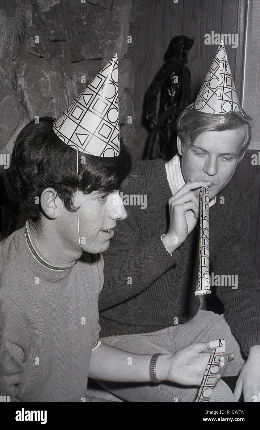 1970 s, historischen, einer Partei, LA, zwei junge Männer mit Party Hüte oder Hütchen auf dem Kopf, einem weht ein Papier Streamer, Los Angeles, USA. Stockfoto