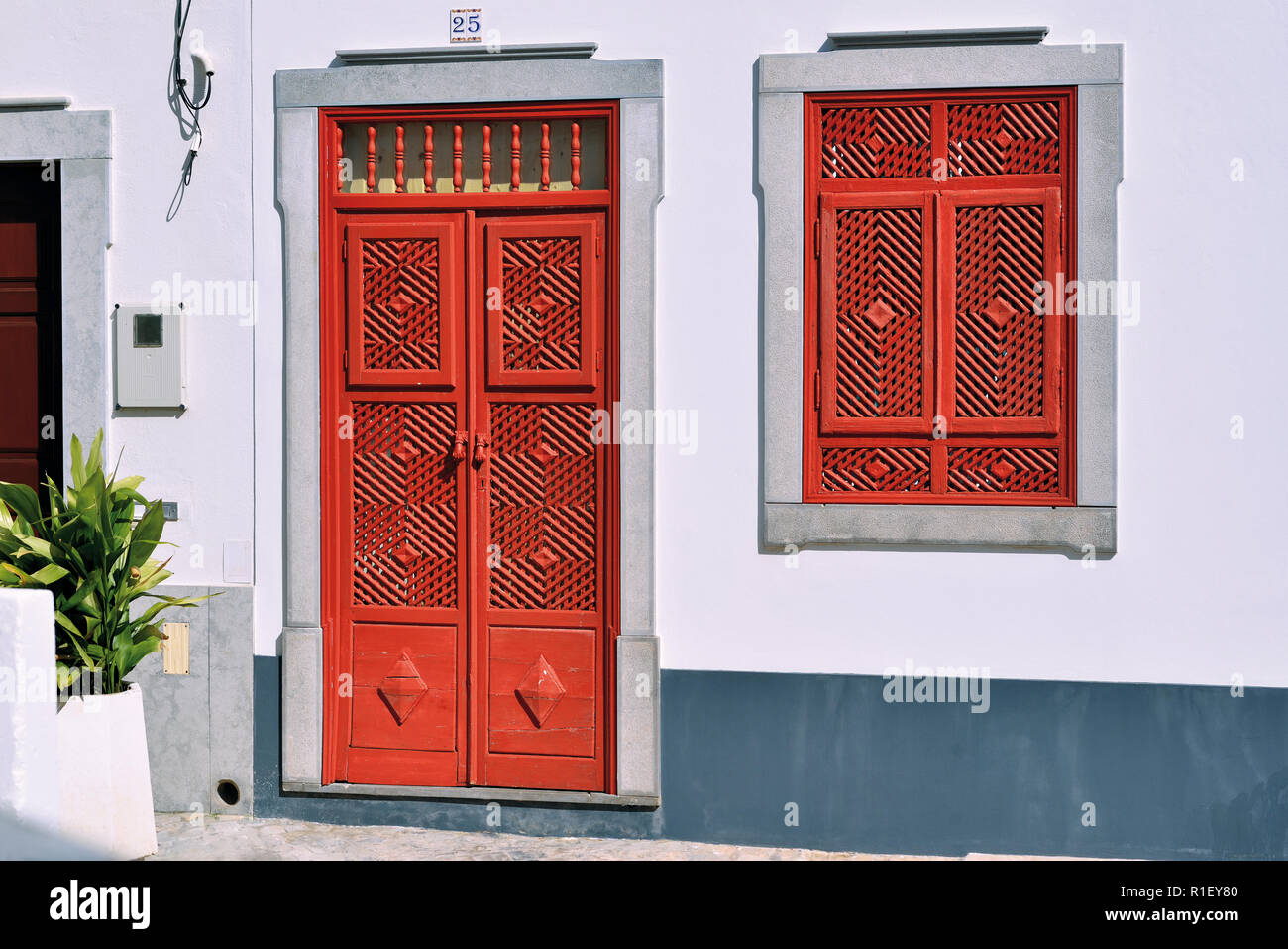 Mit der roten Tür und Fenster im traditionellen arabischen Stil mit verschiedenen Spaltungen in der vor kurzem restaurierten kleinen Haus Stockfoto