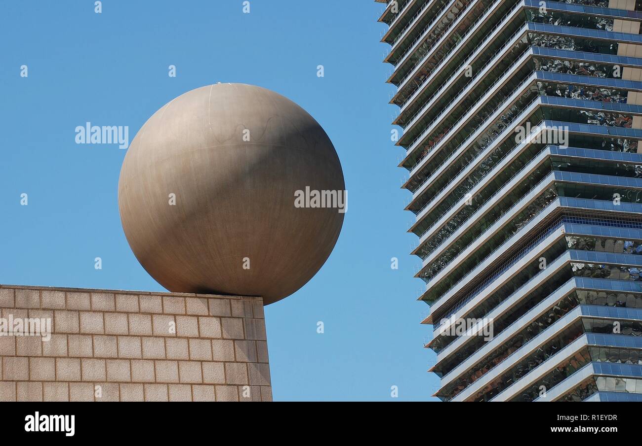 Die Esfera (Kugel) Skulptur von dem Architekten Frank Gehry in Port Olimpic in Barcelona, Spanien am 17. April 2018. Die Mapfre Turm ist im Hintergrund. Stockfoto
