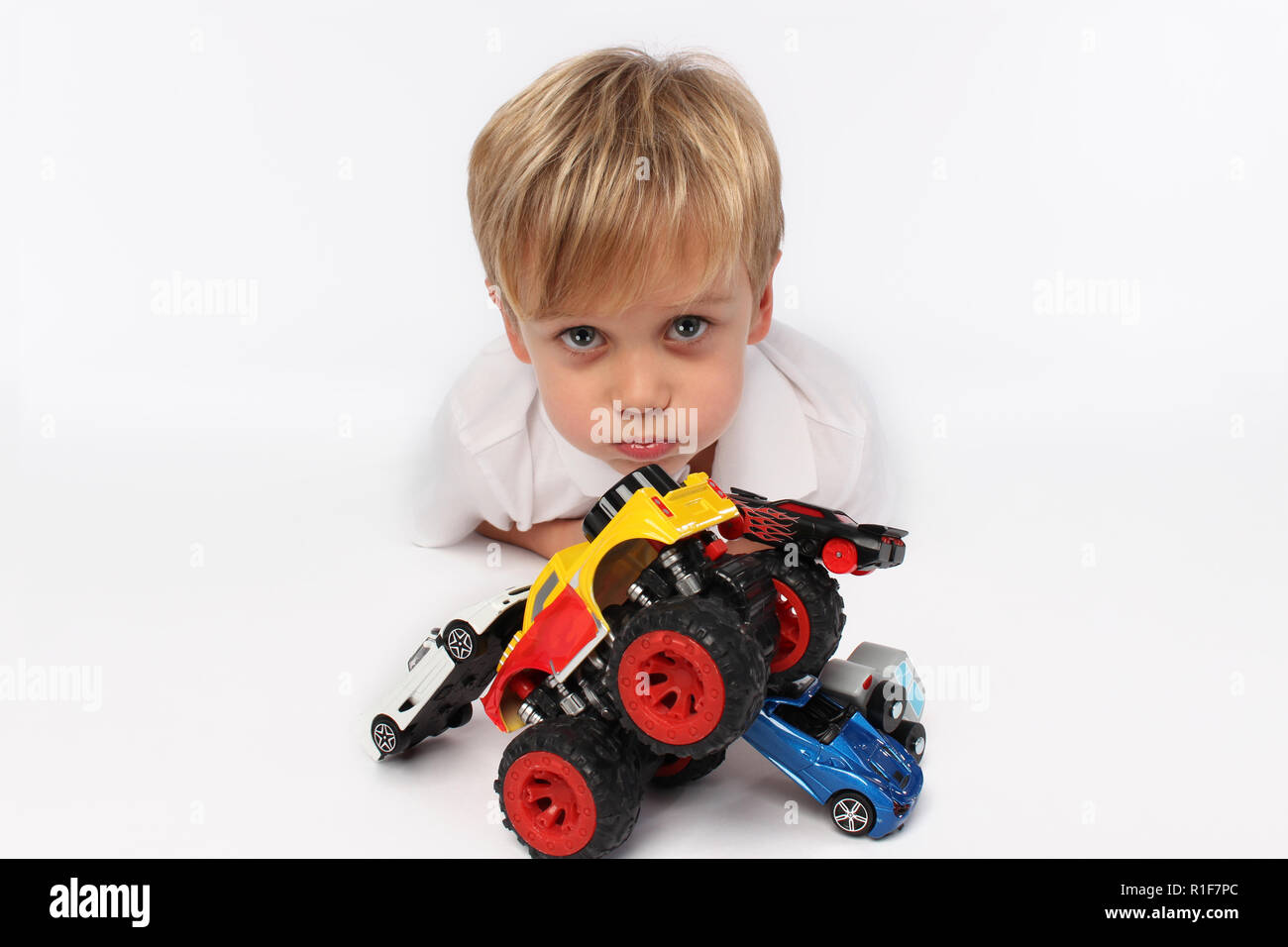 Niedliche Kind Junge mit Auto Spielzeug umgeben Stockfoto