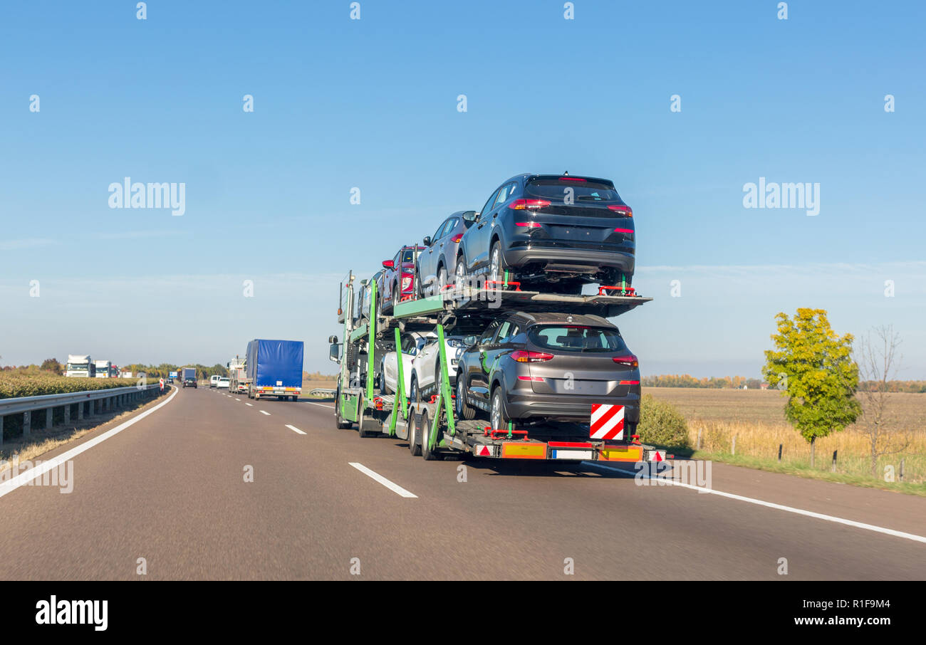 Car carrier Trailer mit neuen Autos für Verkauf auf etagenbetten Plattform auf der Autobahn Stockfoto