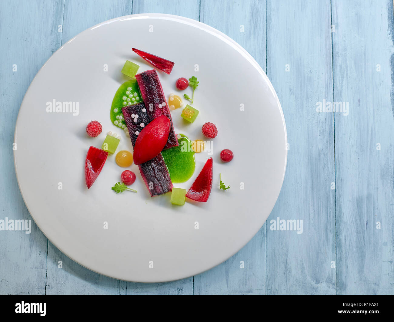 Molekulare lachs Streifen mit Himbeeren icecream und Grün mint Sauce Stockfoto