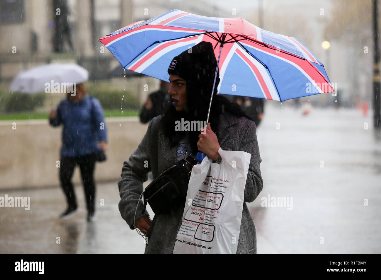 Londoners während heftiger Platzregen in London gesehen. Nach dem Met Office die Temperatur in London ist wahrscheinlich 17 Grad Celsius noch in dieser Woche zu erreichen. Stockfoto