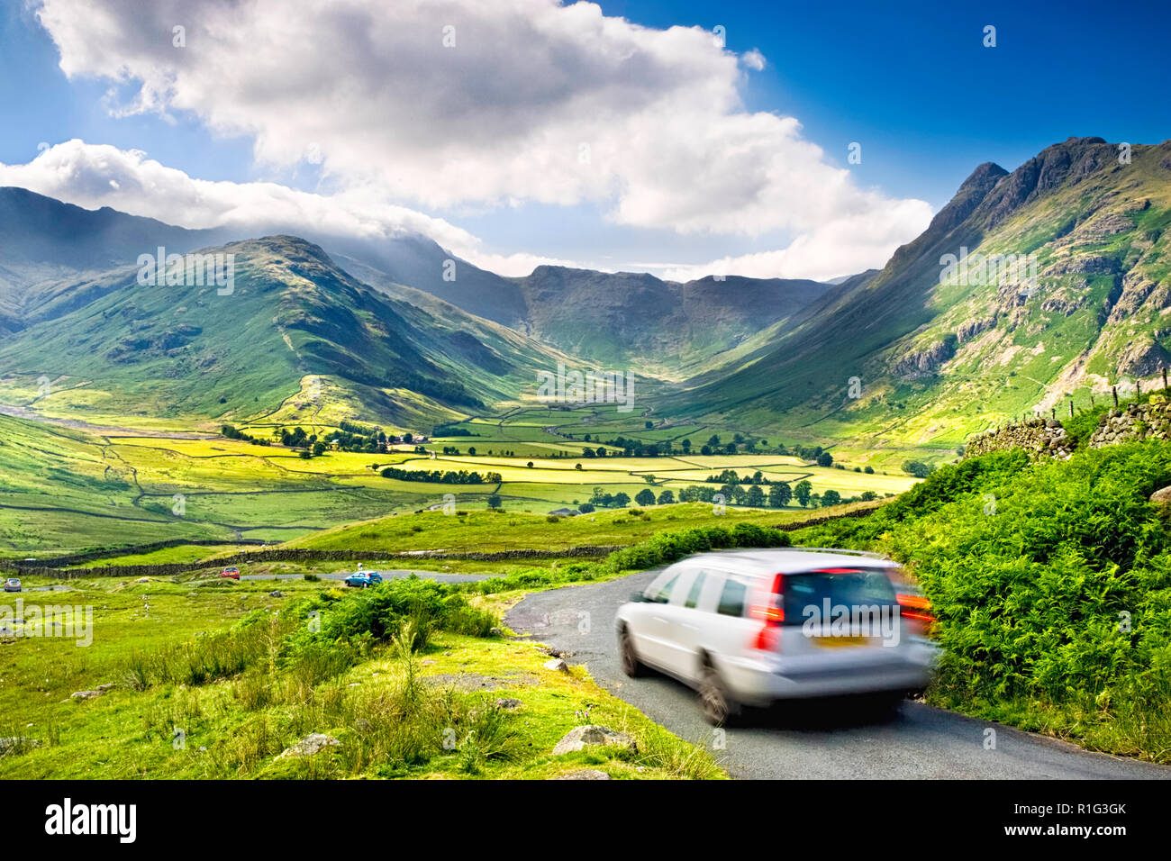 Auto in Bewegung auf einer Landstraße über Great Langdale Valley, mit einem atemberaubenden Blick über den Lake District Hügel, Großbritannien Stockfoto