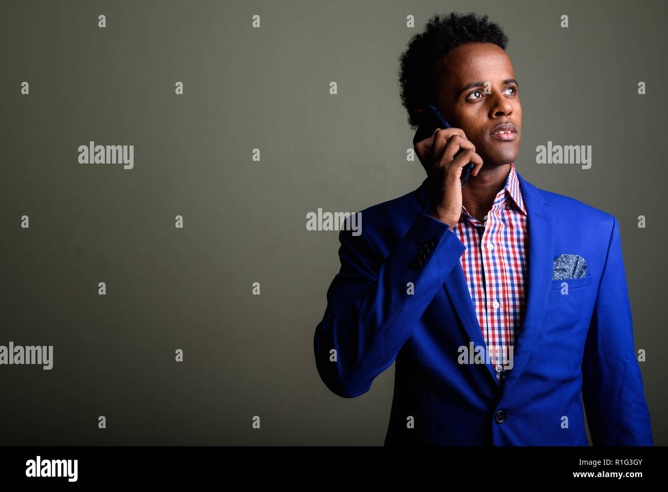 Jungen schönen afrikanischen Geschäftsmann mit Mobiltelefon gegen Co Stockfoto