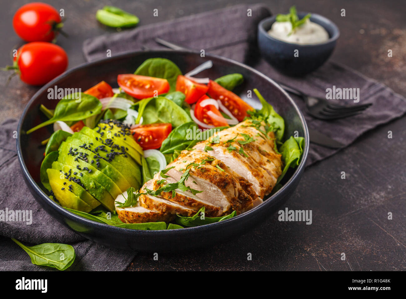 Gegrillte Hühnerbrust und Avocado Salat mit Spinat, Tomaten und Caesar ...