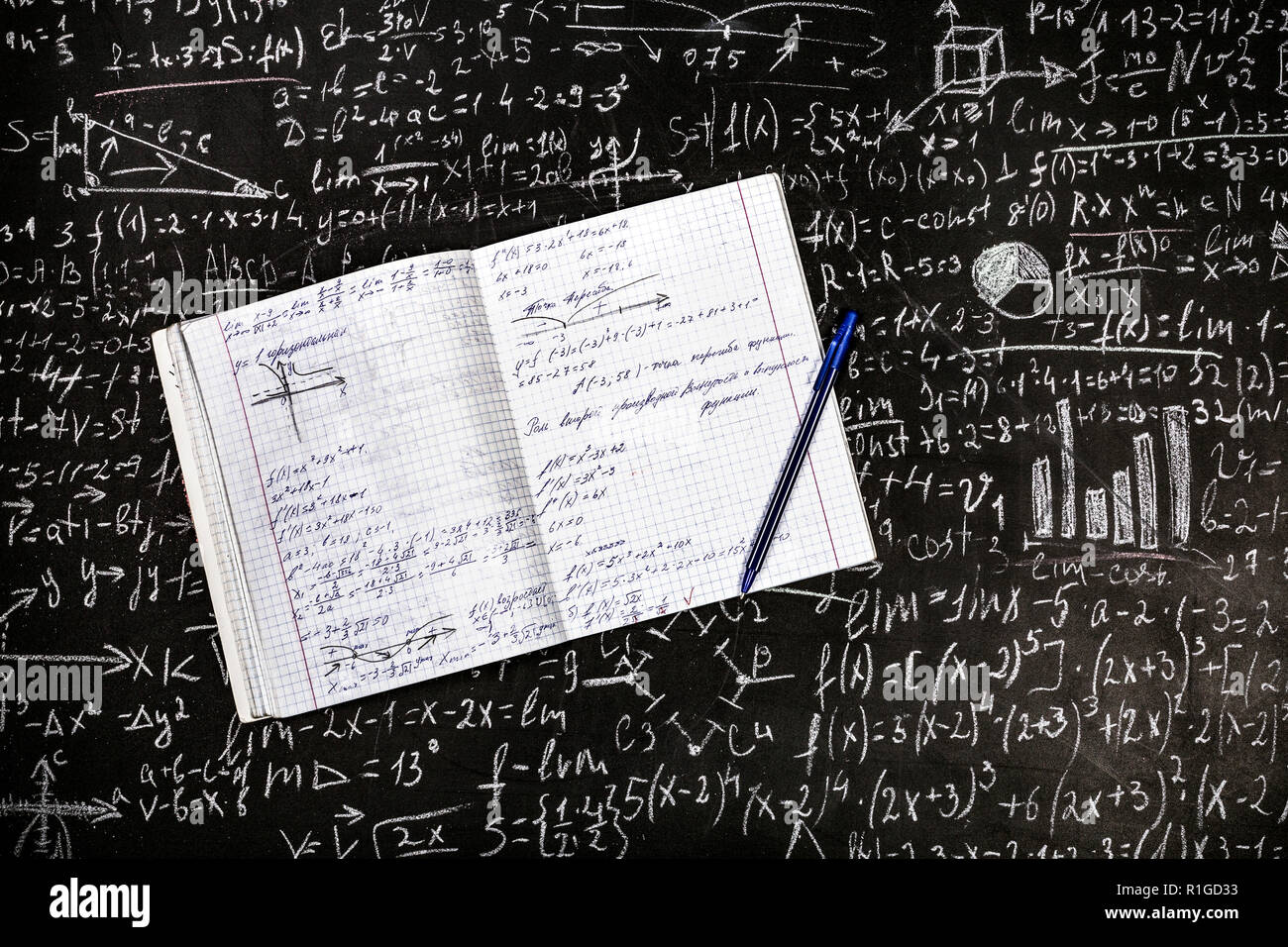 Eine schriftliche Notebook mit einem Stift auf dem Hintergrund der Board mit Beispiele und Formeln Stockfoto