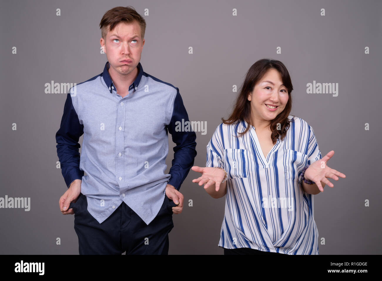 Portrait von multi-ethnische Vielfalt Paar im Studio mit Geld Probleme Stockfoto