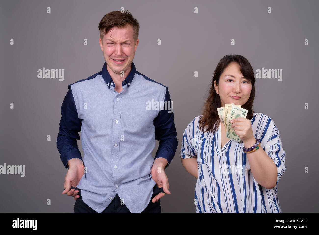 Portrait von multi-ethnische Vielfalt Paar im Studio mit Geld Probleme Stockfoto