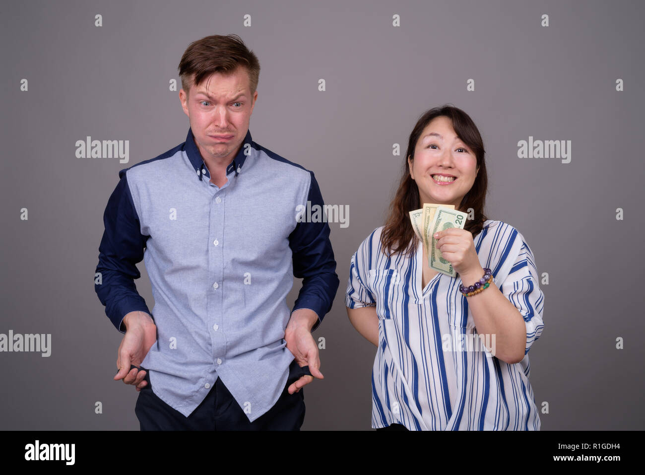 Portrait von multi-ethnische Vielfalt Paar im Studio mit Geld Probleme Stockfoto