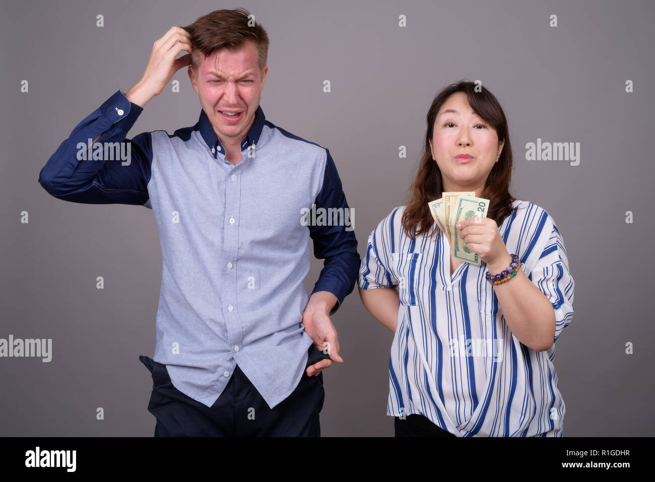 Portrait von multi-ethnische Vielfalt Paar im Studio mit Geld Probleme Stockfoto
