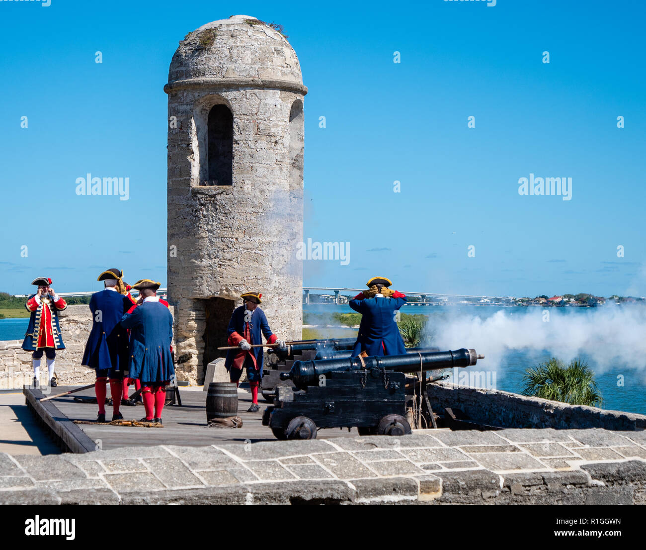 Männer im achtzehnten Jahrhundert spanische Militär Kostüm am Castillo de San Marcos in St Augustine Florida USA Abfeuern einer Kanone auf den Zinnen Stockfoto