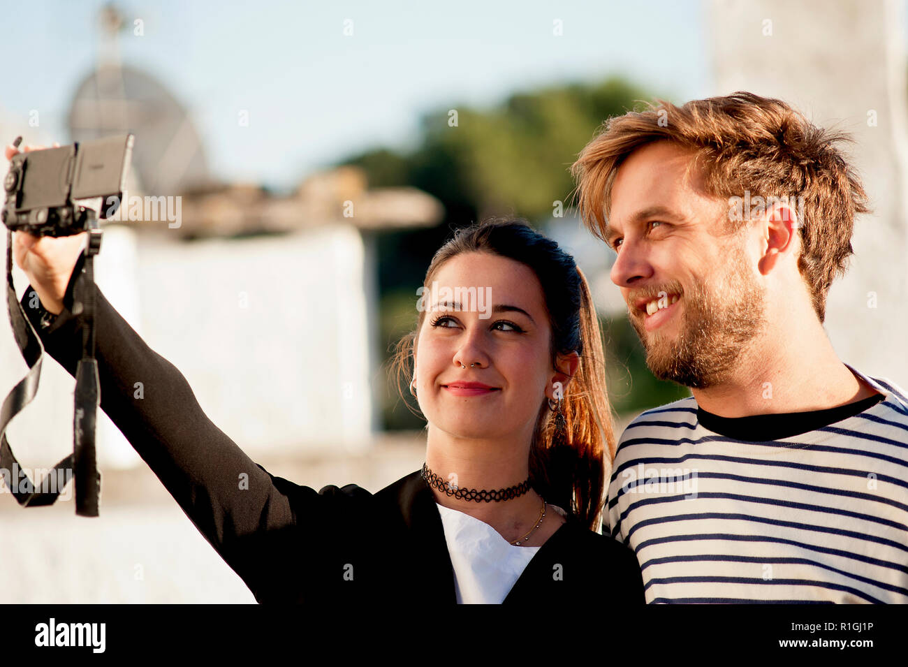 Eine attraktive junge Paar nehmen ein selfie mit ihrer Kamera in Alberobello, ein beliebtes Touristenziel in Apulien, Süditalien. Stockfoto