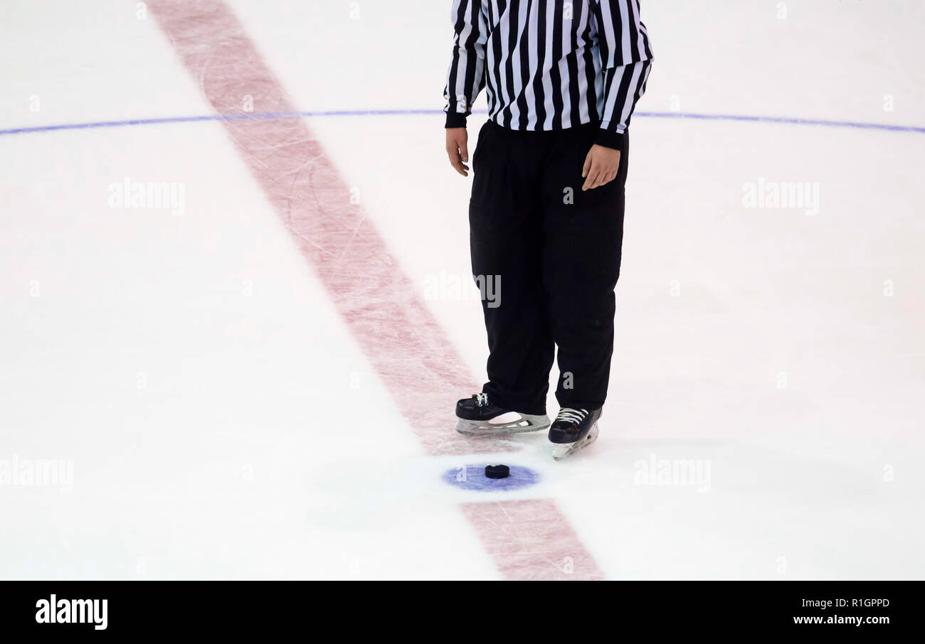 Schwarz hockey puck und Schiedsrichter Beine auf der Eisbahn. Winter Sport. Stockfoto