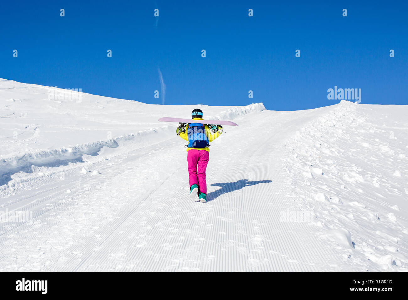 Foto von der Rückseite der weiblichen Athleten mit Snowboard auf den Schultern Stockfoto